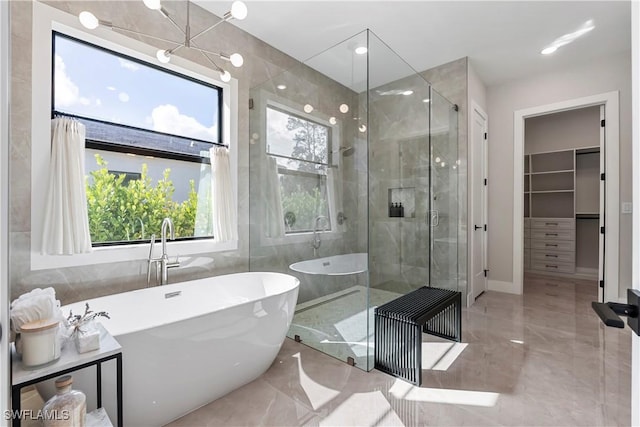 240 Allamanda Way, Naples, FL 34114 - bathroom with marble tiled flooring, a stall shower, a freestanding bath, and a spacious closet