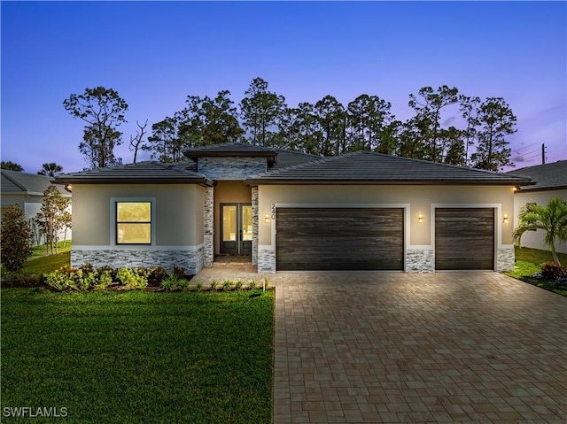 240 Allamanda Way, Naples, FL 34114 - prairie-style house featuring stone siding, a garage, decorative driveway, and stucco siding