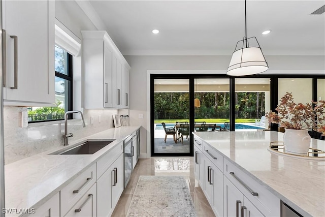 240 Allamanda Way, Naples, FL 34114 - kitchen with white cabinets, light stone countertops, backsplash, hanging light fixtures, and recessed lighting
