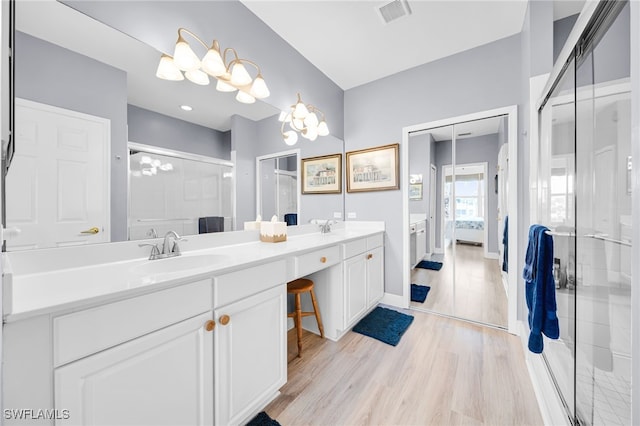 9636 Hemingway Ln Unit 4201, Fort Myers, FL 33913 - bathroom with connected bathroom, a shower stall, double vanity, and wood finished floors