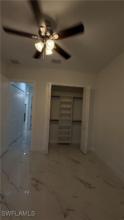 448 Majors Ave S, Lehigh Acres, FL 33974 - unfurnished bedroom featuring a closet, light marble finish floors, and a ceiling fan