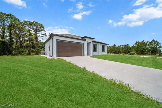 448 Majors Ave S, Lehigh Acres, FL 33974 - contemporary house featuring a front lawn, an attached garage, driveway, and stucco siding
