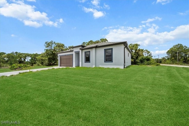 448 Majors Ave S, Lehigh Acres, FL 33974 - view of front of property featuring concrete driveway, an attached garage, a front lawn, and stucco siding