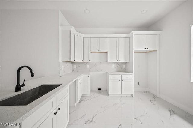 448 Majors Ave S, Lehigh Acres, FL 33974 - kitchen with light marble finish floors, white cabinets, and decorative backsplash