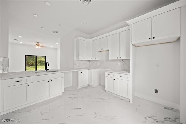448 Majors Ave S, Lehigh Acres, FL 33974 - kitchen with recessed lighting, ceiling fan, white cabinets, tasteful backsplash, and light marble finish flooring