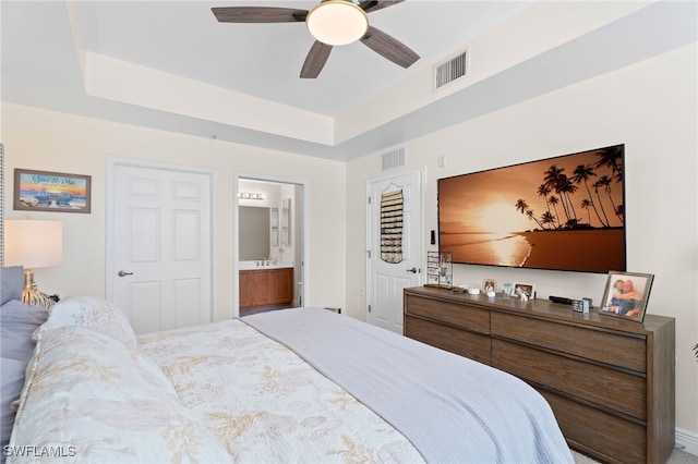 3939 Pomodoro Cir Unit 103, Cape Coral, FL 33909 - bedroom featuring connected bathroom, a tray ceiling, and a ceiling fan