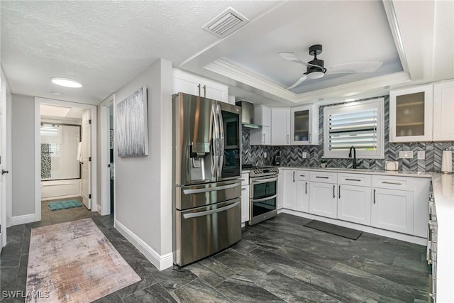 4001 SE 19th Pl Unit B1, Cape Coral, FL 33904 - kitchen featuring appliances with stainless steel finishes, wall chimney range hood, white cabinets, light countertops, and backsplash