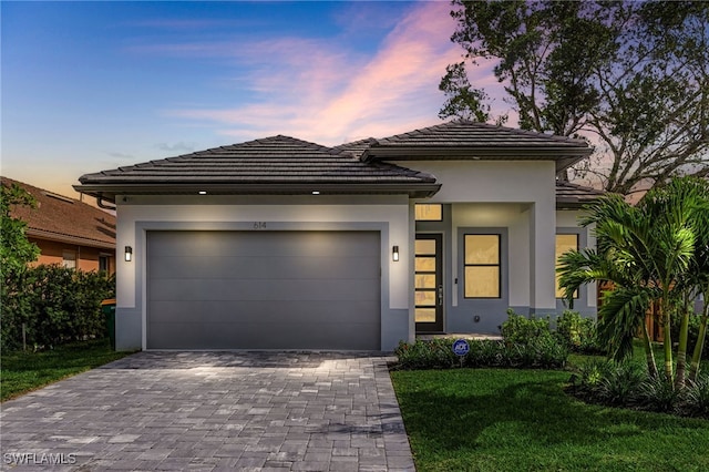 614 105th Ave N, Naples, FL 34108 - view of front of home with stucco siding, a garage, decorative driveway, and a front yard