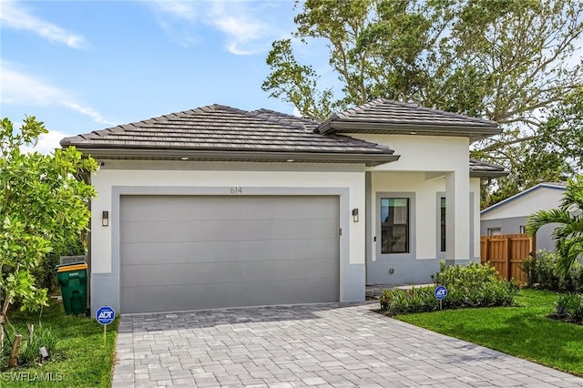 614 105th Ave N, Naples, FL 34108 - view of front of house featuring stucco siding, decorative driveway, a garage, and a tiled roof