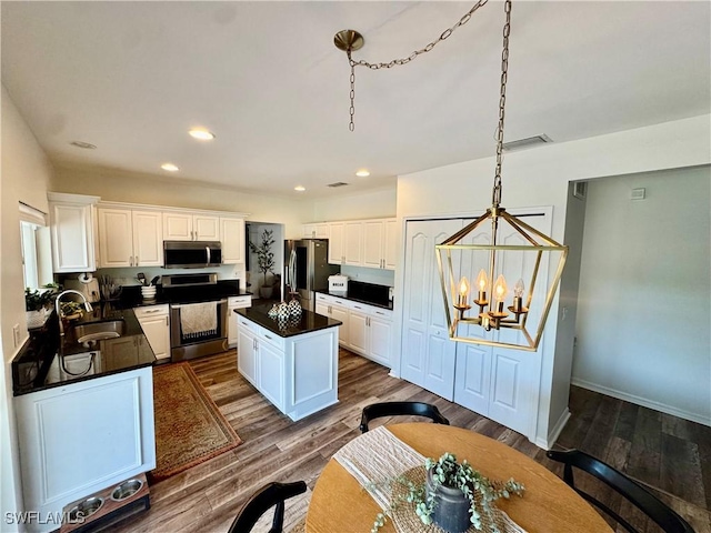 13356 Bristol Park Way, Fort Myers, FL 33913 - kitchen featuring stainless steel appliances, dark countertops, a chandelier, recessed lighting, and white cabinets