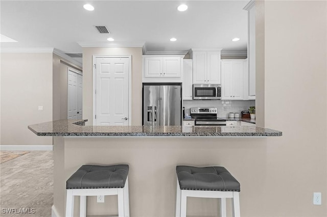 10406 Santiva Way, Fort Myers, FL 33908 - kitchen with appliances with stainless steel finishes, a breakfast bar, crown molding, backsplash, and white cabinets