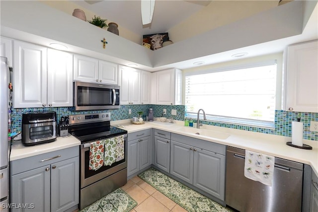 314 Melrose Pl Unit 33, Naples, FL 34104 - kitchen with appliances with stainless steel finishes, gray cabinetry, tasteful backsplash, light tile patterned flooring, and light countertops