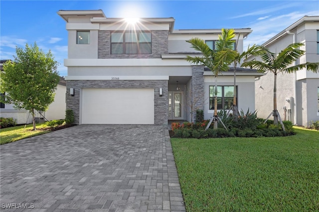 20368 Estero Crossing Blvd, Estero, FL 33928 - modern home featuring stucco siding, stone siding, a garage, and a front lawn