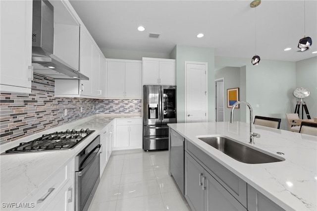 20368 Estero Crossing Blvd, Estero, FL 33928 - kitchen featuring appliances with stainless steel finishes, wall chimney range hood, decorative backsplash, pendant lighting, and light stone countertops