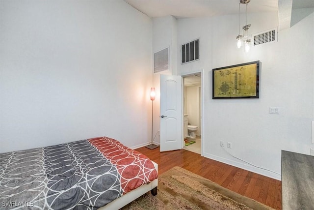 60 Emerald Woods Dr Unit B11, Naples, FL 34108 - bedroom with high vaulted ceiling, wood finished floors, and connected bathroom