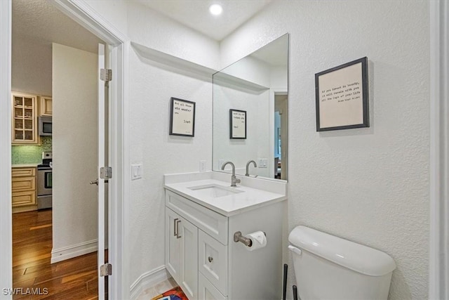 60 Emerald Woods Dr Unit B11, Naples, FL 34108 - bathroom featuring vanity, wood finished floors, and a textured wall