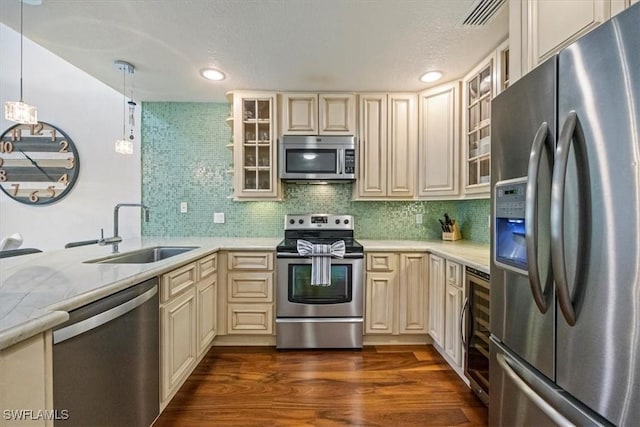 60 Emerald Woods Dr Unit B11, Naples, FL 34108 - kitchen featuring stainless steel appliances, cream cabinetry, light countertops, glass insert cabinets, and recessed lighting