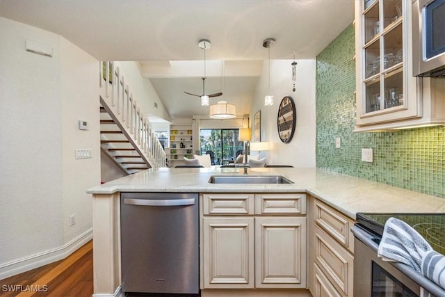 60 Emerald Woods Dr Unit B11, Naples, FL 34108 - kitchen with appliances with stainless steel finishes, a peninsula, wood finished floors, backsplash, and glass insert cabinets