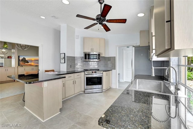 3128 Andorra Ct, Naples, FL 34109 - kitchen with stainless steel appliances, a peninsula, tasteful backsplash, ceiling fan, and dark stone counters