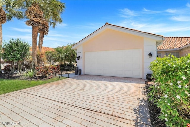 3128 Andorra Ct, Naples, FL 34109 - view of front of home with stucco siding, a garage, and driveway