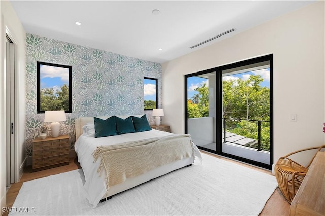 850 10th St N, Naples, FL 34102 - bedroom with wallpapered walls, access to outside, light wood finished floors, and an accent wall