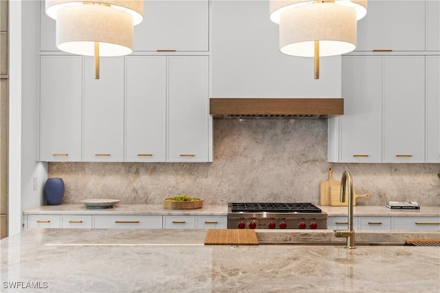 850 10th St N, Naples, FL 34102 - kitchen featuring white cabinets, light stone counters, backsplash, decorative light fixtures, and stainless steel gas stovetop