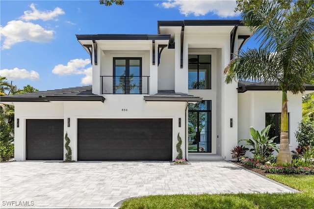 850 10th St N, Naples, FL 34102 - contemporary house with stucco siding, a balcony, decorative driveway, and an attached garage