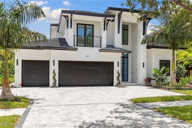 850 10th St N, Naples, FL 34102 - contemporary house with a balcony, stucco siding, decorative driveway, and a garage