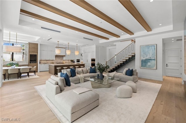 850 10th St N, Naples, FL 34102 - living room with light wood-style flooring, stairs, and beam ceiling