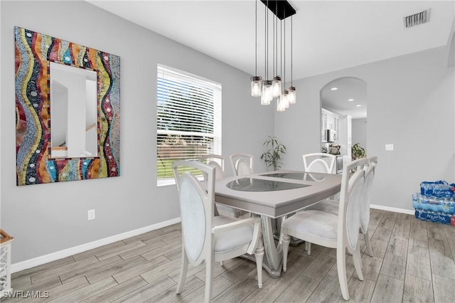 8094 Silver Birch Way, Lehigh Acres, FL 33971 - dining room with light wood-style flooring, healthy amount of natural light, arched walkways, and recessed lighting