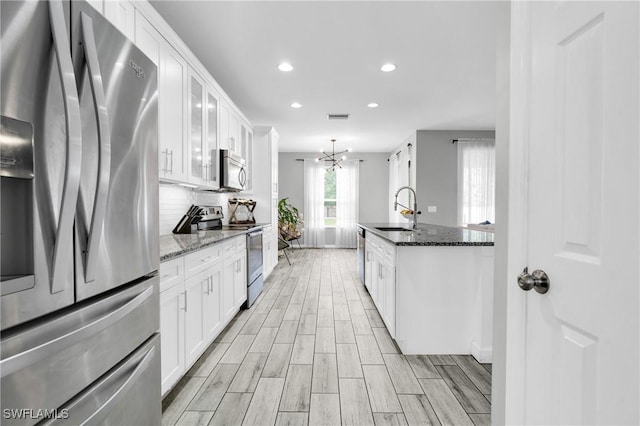8094 Silver Birch Way, Lehigh Acres, FL 33971 - kitchen with appliances with stainless steel finishes, recessed lighting, tasteful backsplash, white cabinetry, and a chandelier