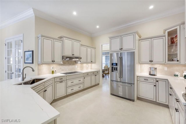 6632 Glen Arbor Way, Naples, FL 34119 - kitchen with high end refrigerator, under cabinet range hood, light stone counters, black electric stovetop, and tasteful backsplash