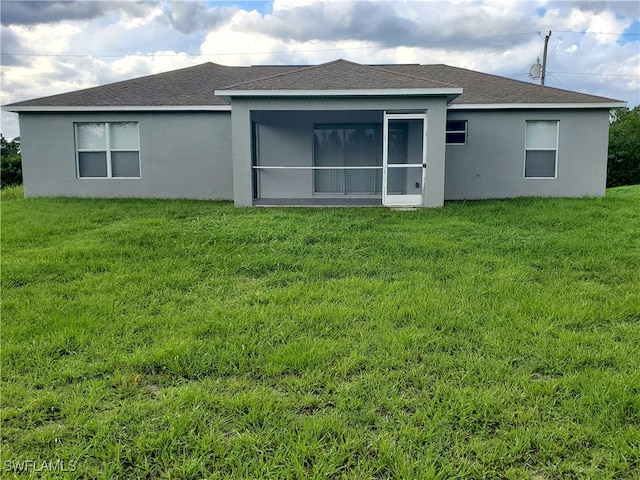 3009 44th St W, Lehigh Acres, FL 33971 - back of property with a lawn, stucco siding, and roof with shingles