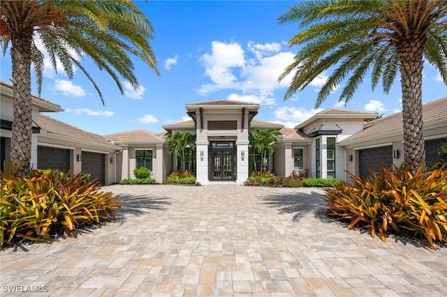4297 Deephaven Ln, Naples, FL 34119 - view of front facade featuring a garage, decorative driveway, and stucco siding