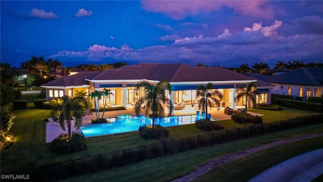 4297 Deephaven Ln, Naples, FL 34119 - back of house at dusk with a fenced backyard, an outdoor hangout area, and a patio