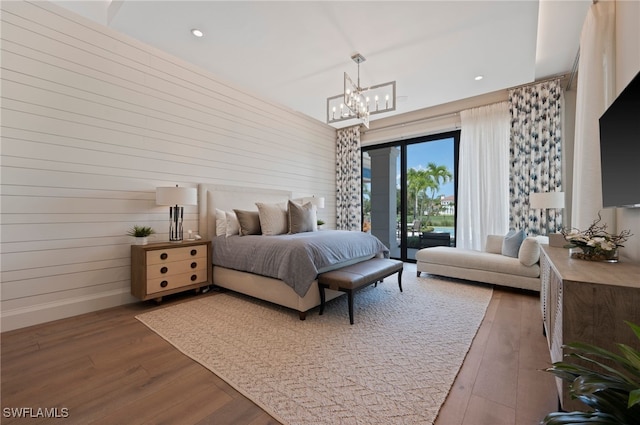 4297 Deephaven Ln, Naples, FL 34119 - bedroom with wood finished floors, a chandelier, access to exterior, recessed lighting, and wooden walls