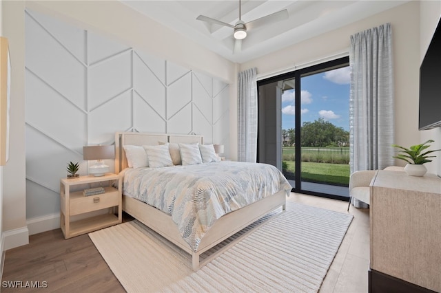 4297 Deephaven Ln, Naples, FL 34119 - bedroom featuring access to exterior, wood finished floors, and a decorative wall
