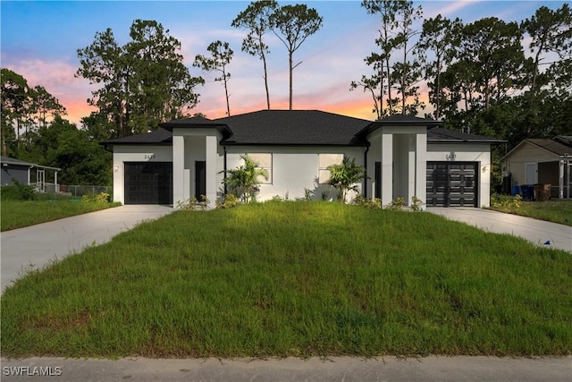 2429/2431 Lola Ave S, Lehigh Acres, FL 33973 - view of front facade featuring an attached garage, concrete driveway, stucco siding, and a front lawn