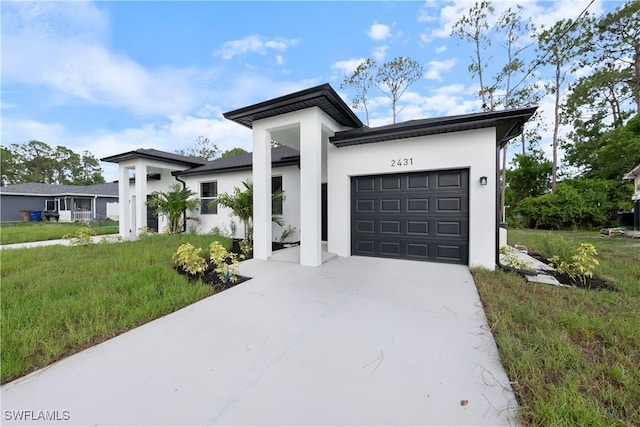 2429/2431 Lola Ave S, Lehigh Acres, FL 33973 - view of front of home featuring concrete driveway, stucco siding, and a garage