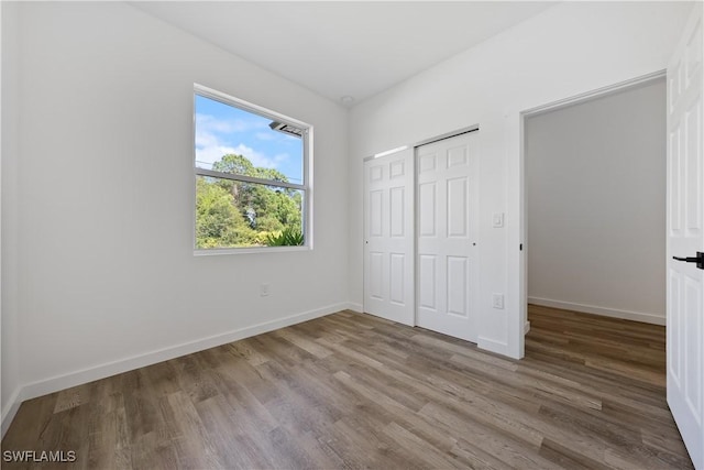 2429/2431 Lola Ave S, Lehigh Acres, FL 33973 - unfurnished bedroom featuring wood finished floors and a closet