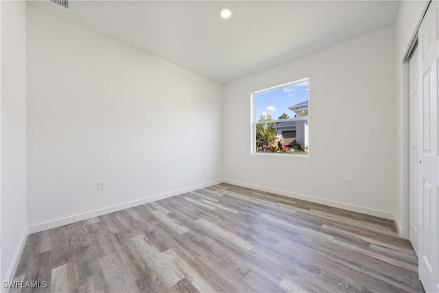 2429/2431 Lola Ave S, Lehigh Acres, FL 33973 - unfurnished bedroom with wood finished floors, a closet, and recessed lighting