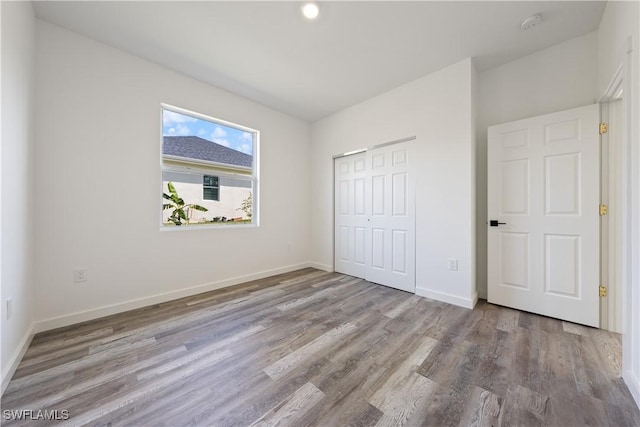 2429/2431 Lola Ave S, Lehigh Acres, FL 33973 - unfurnished bedroom featuring wood finished floors and a closet