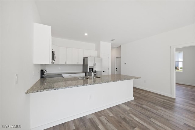 2429/2431 Lola Ave S, Lehigh Acres, FL 33973 - kitchen with stainless steel appliances, a peninsula, light stone countertops, white cabinetry, and wood finished floors