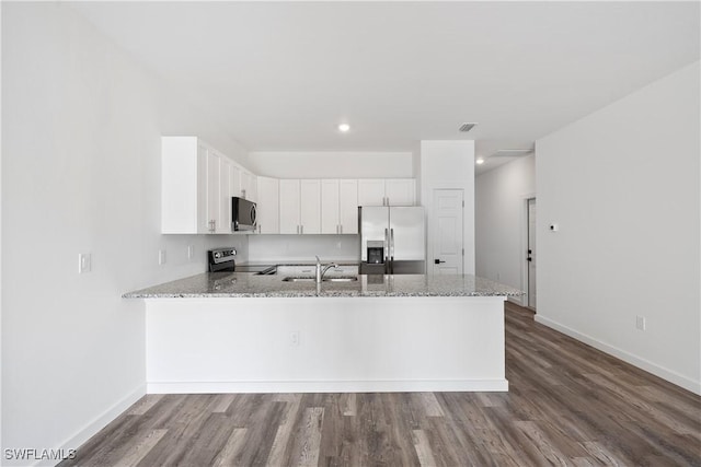 2429/2431 Lola Ave S, Lehigh Acres, FL 33973 - kitchen with appliances with stainless steel finishes, a peninsula, dark wood finished floors, light stone counters, and recessed lighting