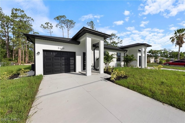 2429/2431 Lola Ave S, Lehigh Acres, FL 33973 - view of front of home featuring driveway, an attached garage, stucco siding, and a front lawn