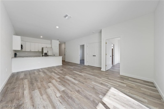 2429/2431 Lola Ave S, Lehigh Acres, FL 33973 - unfurnished living room featuring light wood-style flooring and recessed lighting