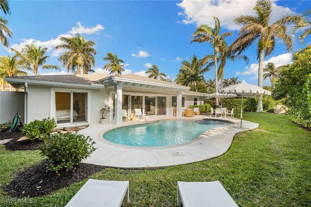 320 Putter Point Dr, Naples, FL 34103 - back of house with a lawn, stucco siding, an outdoor pool, and a patio