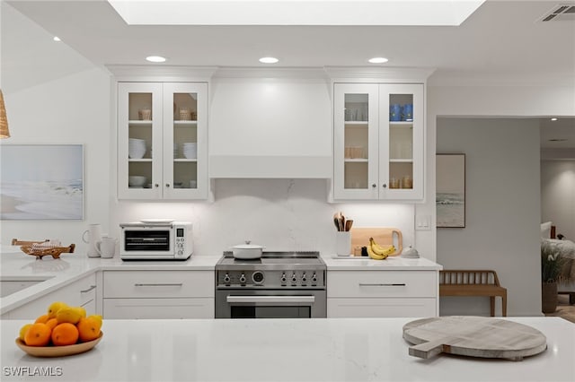 320 Putter Point Dr, Naples, FL 34103 - kitchen featuring electric stove, a skylight, light countertops, recessed lighting, and white cabinetry