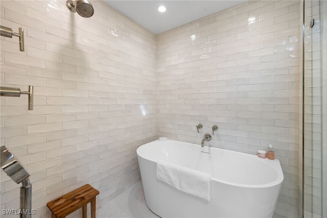 320 Putter Point Dr, Naples, FL 34103 - bathroom featuring tile walls, a freestanding tub, recessed lighting, and tile patterned flooring