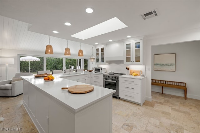 320 Putter Point Dr, Naples, FL 34103 - kitchen with high end stove, premium range hood, a skylight, stone tile flooring, and recessed lighting